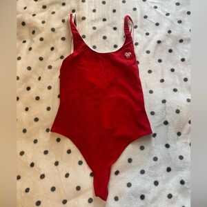 Red and white bordered TNA bodysuit size small.